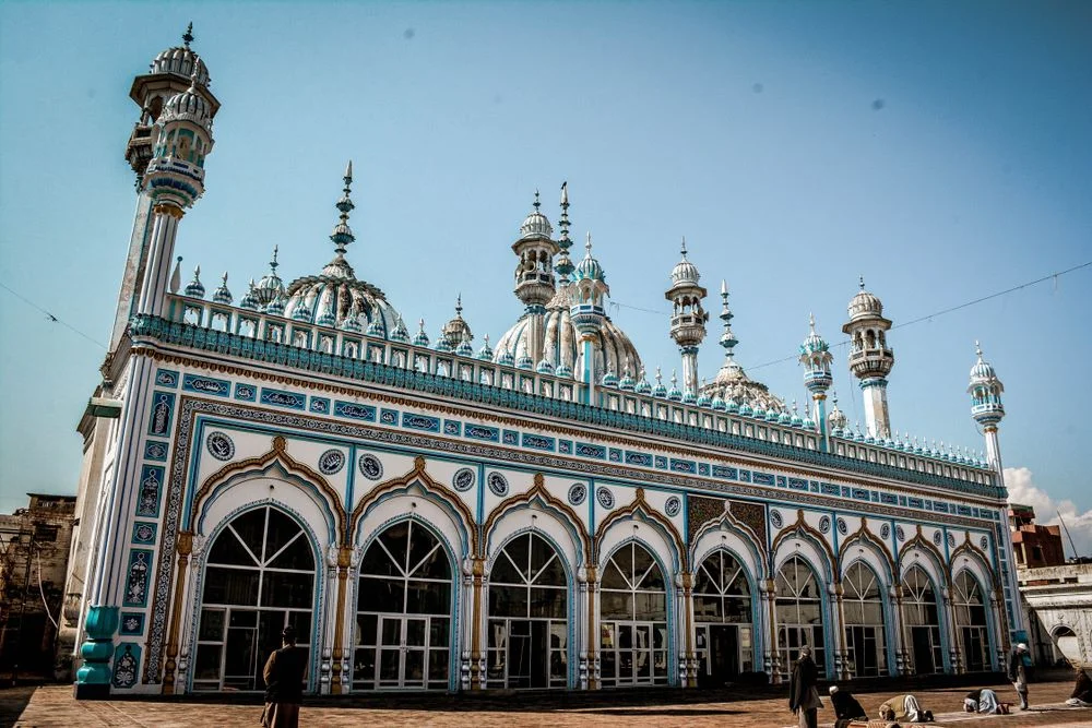 A mosque facade in blue and white colors blue sky in background